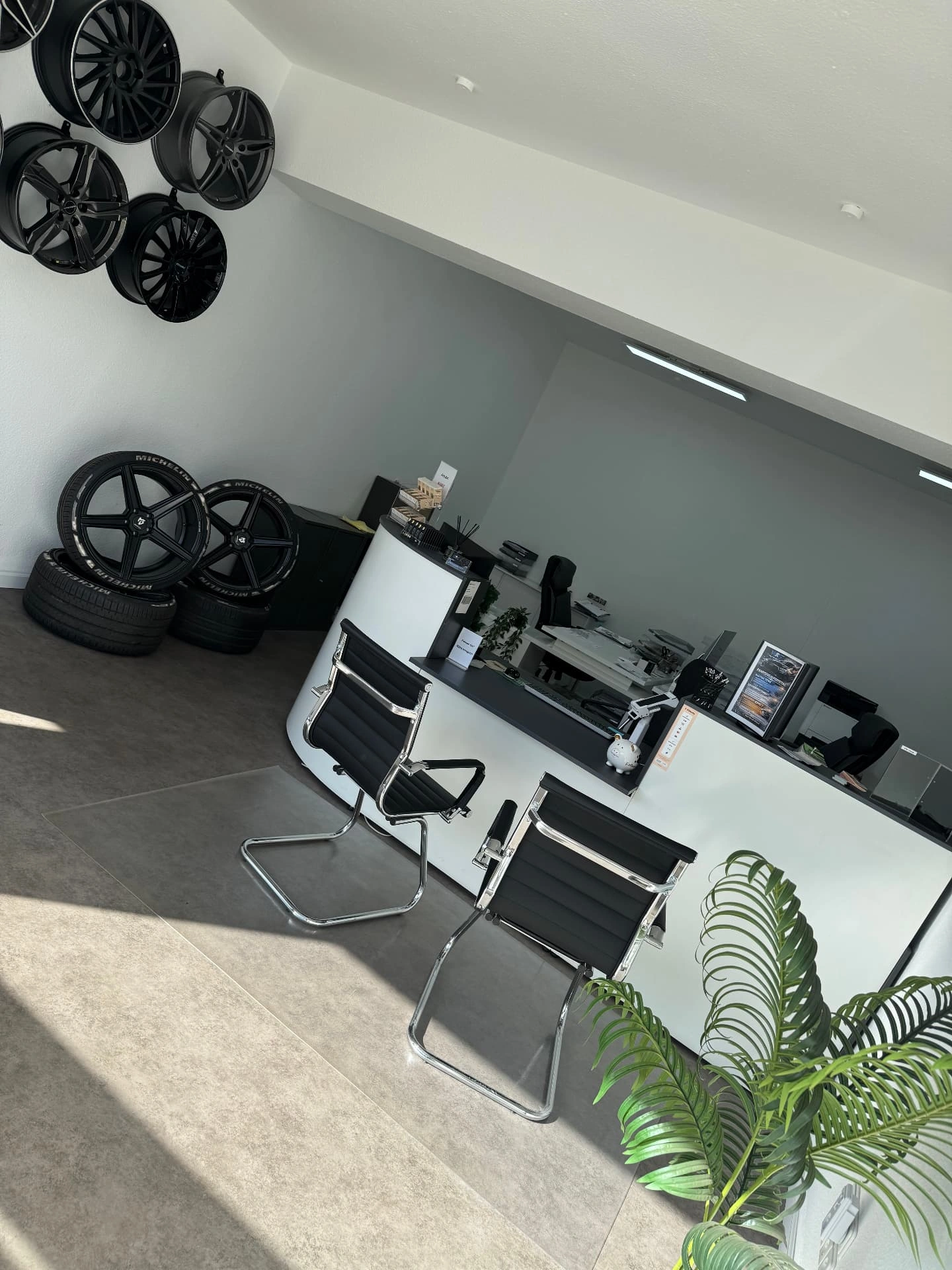 Empfang im Büro von W&S Automotive mit Tresen, Kundenstühlen und Rädern