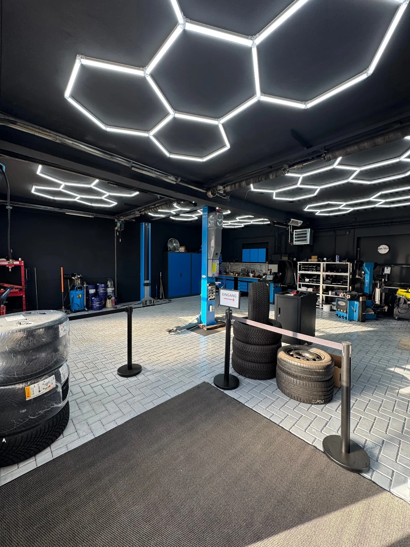 Innenansicht der modernisierten Werkstatt von W&S Automotive mit Hebebühne und sechseckiger LED-Deckenbeleuchtung